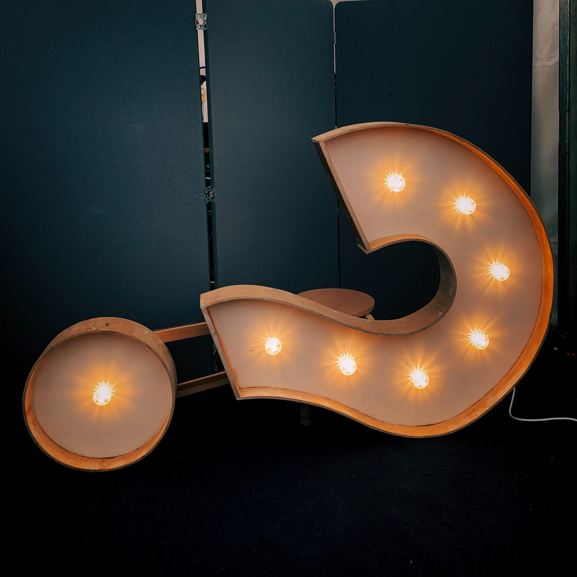 illuminated question mark hanging from a wall